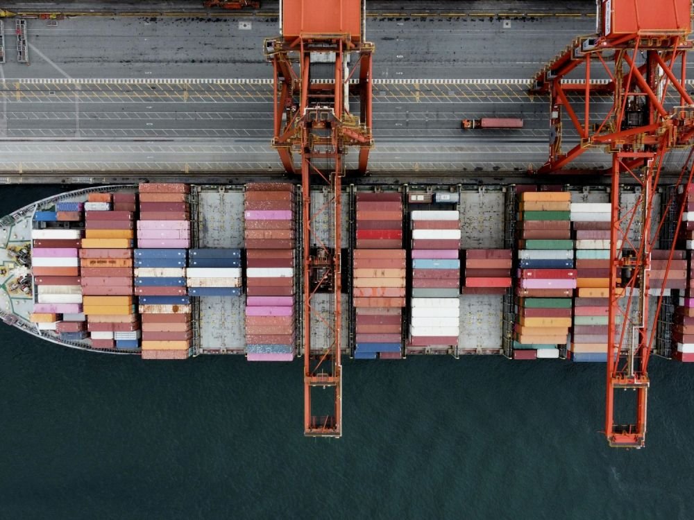Aerial view of a container ship being loaded by gantry cranes at a port