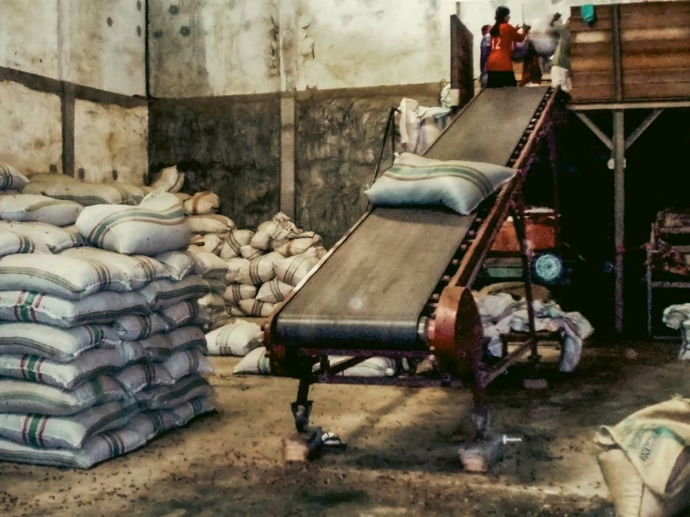 Stacked sacks and a loading conveyor inside a produce warehouse